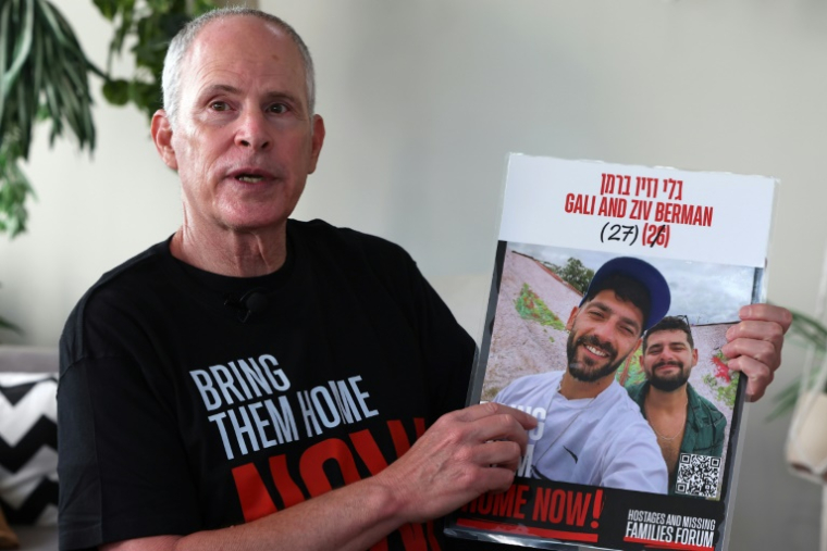 L'Israélo-américain Keith Siegel, qui a passé 484 jours en captivité à Gaza, montre la photo de deux otages, Gali and Ziv Berman, avec lesquels il a été retenu, lors d'un entretien avec l'AFP, le 12 juin 2025 à Tel-Aviv ( AFP / JACK GUEZ )