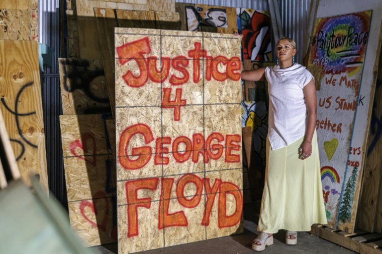 Kenda Zellner-Smith pose dans un container de stockage avec un des panneaux de bois qu'elle a collectés en 2020 après la mort de George Floyd, le 25 mai 2025 à Minneapolis, dans le Minnesota ( AFP / Kerem YUCEL )