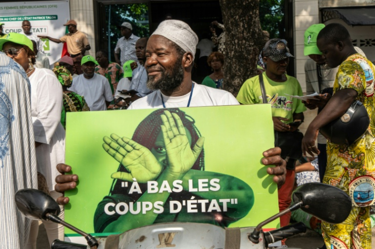 Un partisan du président du Bénin Patrice Talon montre une pancarte durant un rassemblement de soutien au chef de l'Etat le 10 décembre 2025 à Cotonou ( AFP / Yanick Folly )