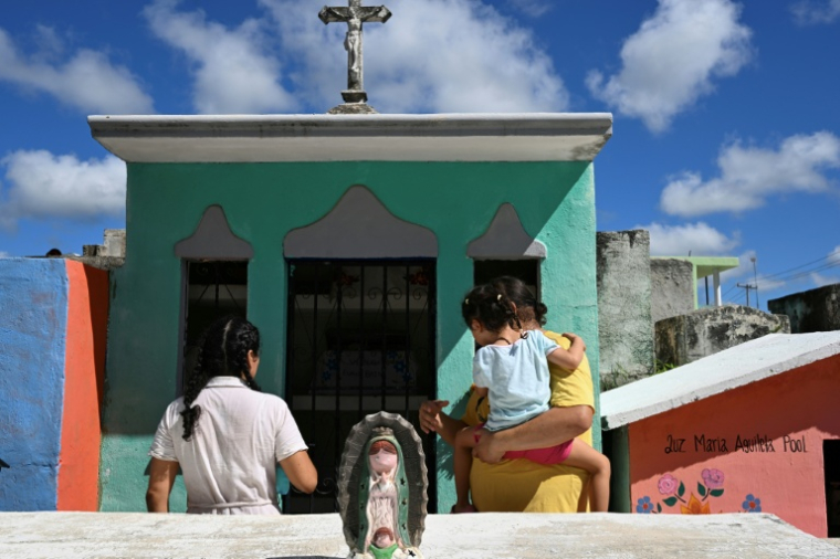 Des personnes se préparent à nettoyer les restes d'un proche avant les célébrations du Jour des morts au cimetière de Pomuch, dans l'État de Campeche, au Mexique, le 19 octobre 2025 ( AFP / Yuri CORTEZ )