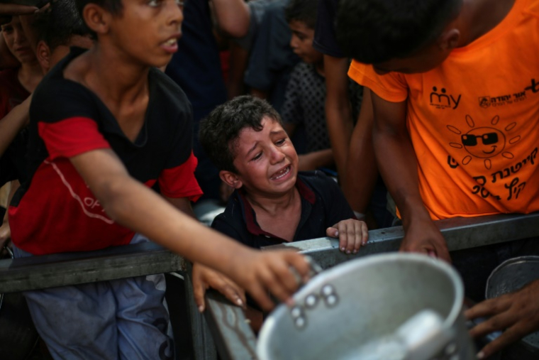 Un garçon palestinien pleure en attendant de recevoir un repas chaud à Nousseira, dans la bande de Gaza, le 4 septembre 2025 ( AFP / Eyad BABA )