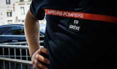 Un pompier avec "en grève" scratché sur la poitrine, devant  l'hôtel de Beauvau, à Paris, le 13 août 2026 ( AFP / SIMON WOHLFAHRT )
