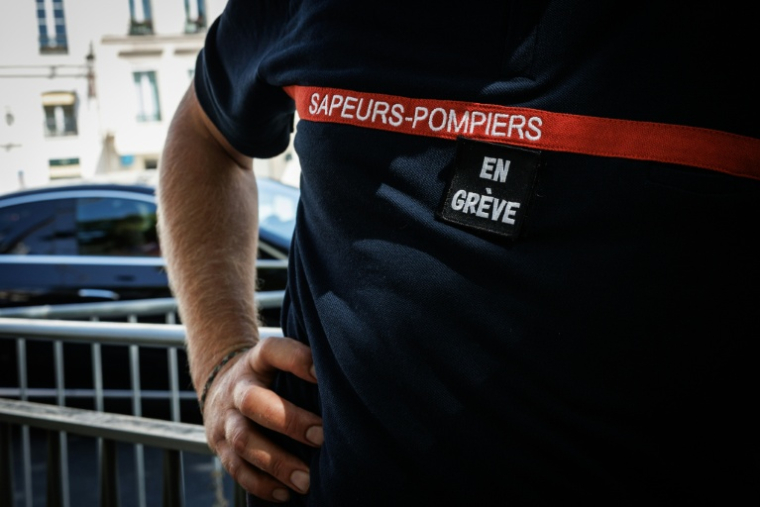 Un pompier participant à une action de protestation près du ministère de l'Intérieur le 13 août 2026 à Paris ( AFP / SIMON WOHLFAHRT )