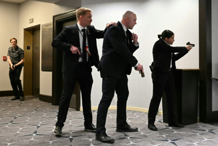 Des agents sont armes au poing après que des détonations ont été entendues au dîner des correspondants de la Maison Blanche, à l'hôtel Washington Hilton, le 25 avril 2026 à Washington ( AFP / Mandel NGAN )