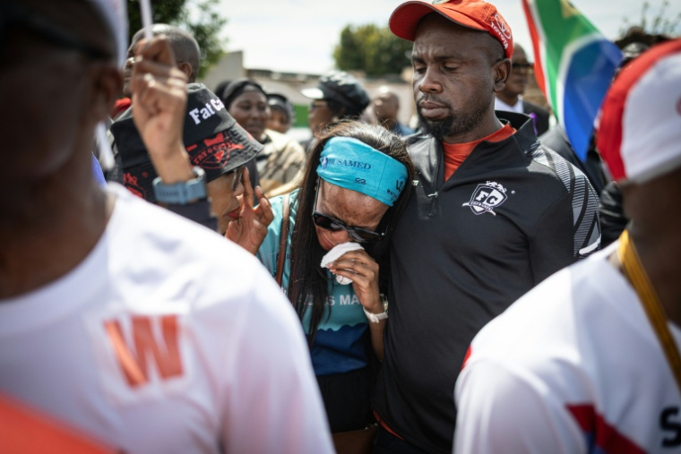 Un couple de coureurs venu honorer la mémoire d'Elizabeth Moselakgomo, lors de ses funérailles dans la province de Mpumalanga (Afrique du Sud), le 20 septembre 2026 ( AFP / EMMANUEL CROSET )