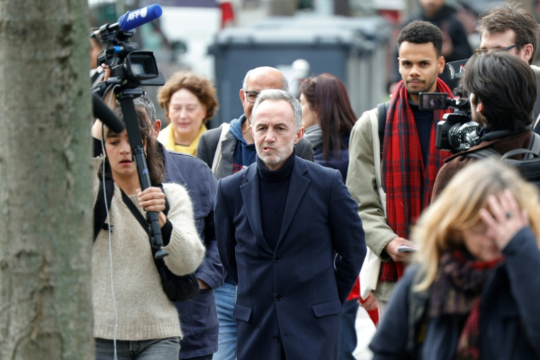 Emmanuel Grégoire (c), candidat socialiste (PS) à la mairie de Paris, entouré par des journalistes, déambule dans le quartier des Olympiades à Paris, dans le cadre de sa campagne électorale au lendemain du 1er tour des municipales ( AFP / GEOFFROY VAN DER HASSELT )