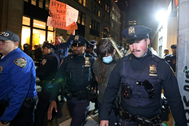 Des agents du NYPD arrêtent un manifestant lors d'une manifestation contre l'Immigration and Customs Enforcement (ICE) à New York le 22 octobre 2025 ( AFP / TIMOTHY A. CLARY )