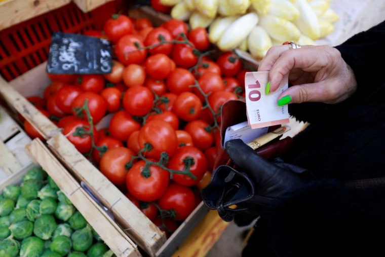 Un client paie avec un billet de dix euros dans un marché local à Aix-en-Provence