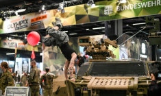 Un visiteur fait le poirier sur un véhicule de l'armée allemande, sur le stand de la Bundeswehr, au plus grand salon mondial du fitness, la Fibo, à Cologne (ouest de l'Allemagne), le 16 avril  ( AFP / Ina FASSBENDER )