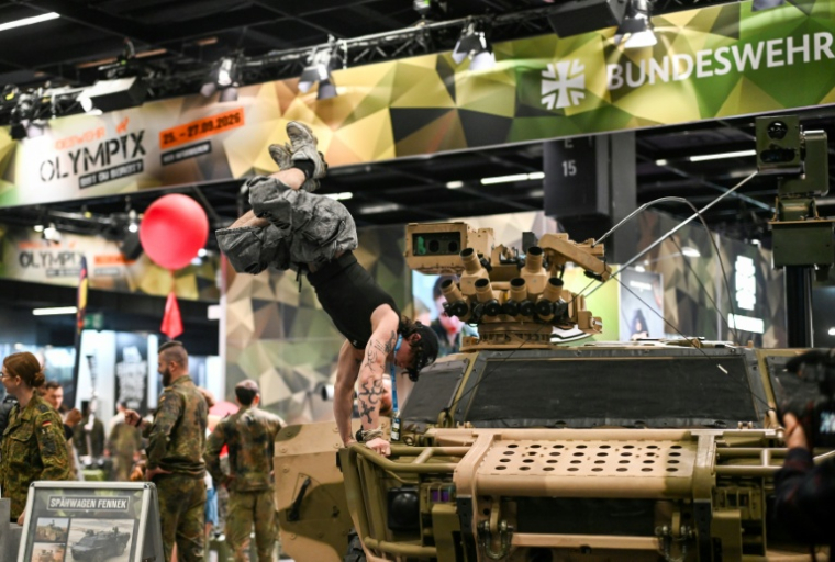 Un visiteur fait le poirier sur un véhicule de l'armée allemande, sur le stand de la Bundeswehr, au plus grand salon mondial du fitness, la Fibo, à Cologne (ouest de l'Allemagne), le 16 avril  ( AFP / Ina FASSBENDER )