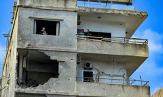 Des habitants dans un immeuble endommagé par une frappe israélienne octurne à Tyr, dans le sud du Liban, le 16 mai 2026 ( AFP / Kawnat HAJU )