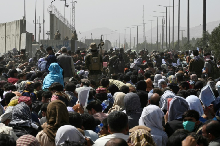 Des milliers d'Afghans sur une route proche du secteur militaire de l'aéroport de Kaboul espèrent pouvoir fuir le pays après la prise de la capitale par les talibans, le 16 août 2021  ( AFP / Wakil KOHSAR )