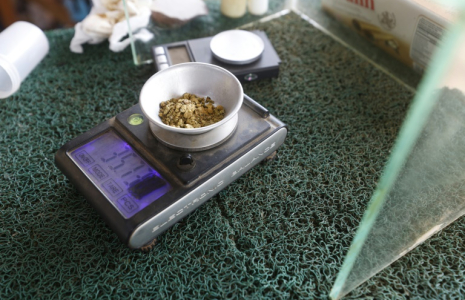 Un commerçant pèse sur une balance numérique l'or en poudre d'un client dans la ville minière d'El Dorado, dans l'Etat de Bolivar, le 24 mai 2025 au Venezuela ( AFP / Pedro MATTEY )