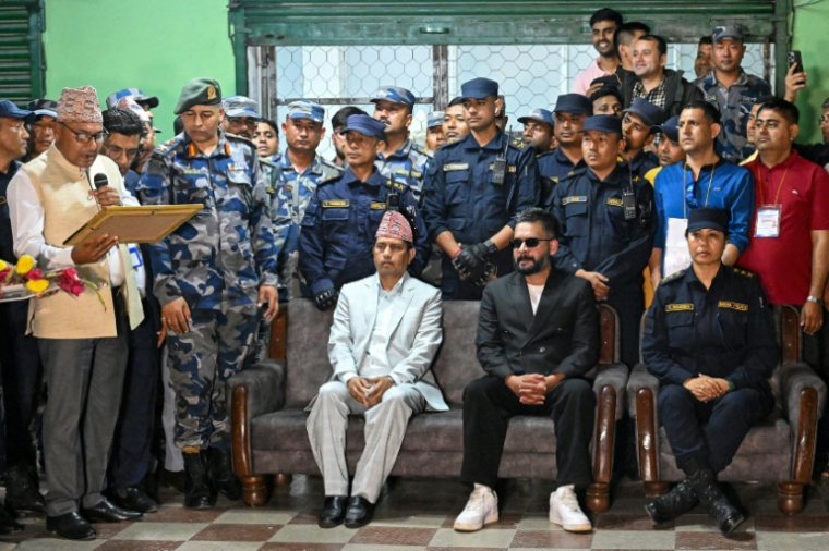 Balendra Shah (au centre, à droite), du Rastriya Swatantra Party (RSP), attend le 7 mars 2026 à Damak, dans le district de Jhapa, le document de certification de sa victoire aux législatives du Népal  ( AFP / Prakash MATHEMA )