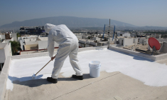 un homme peint un toit en blanc (Crédits: Adobe Stock)
