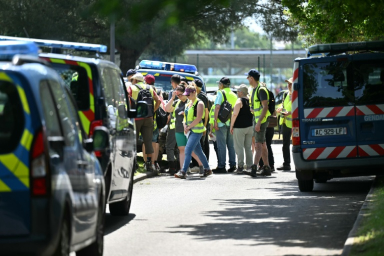 Des volontaires marchent en file indienne le long d'une route à Saint-Étienne-de-Montluc, dans le cadre d'une recherche visant à recueillir des informations concernant Manon Relandeau, disparue depuis le 27 mars ( AFP / Lou BENOIST )