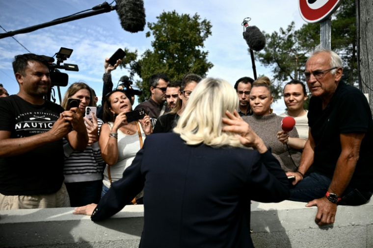 La candidate du RN à la présidentielle, Marine Le Pen, discute avec des habitants et des sympathisants lors d'un déplacement au Porge, en Gironde, le 17 septembre 2026 ( AFP / Philippe LOPEZ )