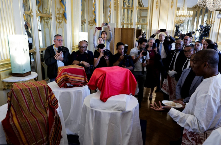 Un homme bénit trois crânes lors d'une cérémonie pour leur restitution à Madagascar, au ministère de la Culture à Paris, le 26 août 2025 ( AFP / STEPHANE DE SAKUTIN )