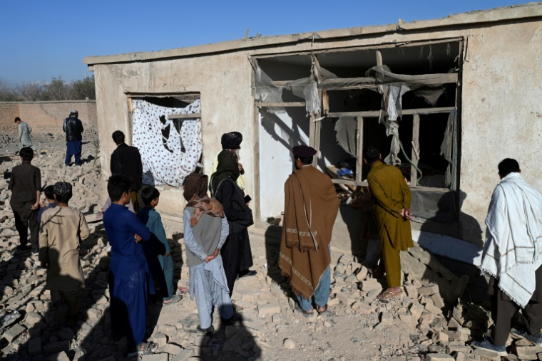 Des habitants devant une maison endommagée par un raid aérien pakistanais, en périphérie de Kaboul, le 13 mars 2026 en Afghanistan ( AFP / Wakil KOHSAR )