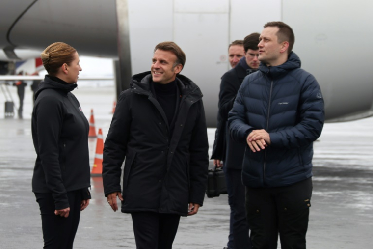 La Première ministre danoise Mette Frederiksen (G) et le chef du gouvernement groenlandais, Jens-Frederik Nielsen(D), accueillent le président français Emmanuel Macron à l'aéroport de Nuuk, au Groenland, le 15 juin 2025 ( AFP / Ludovic MARIN )