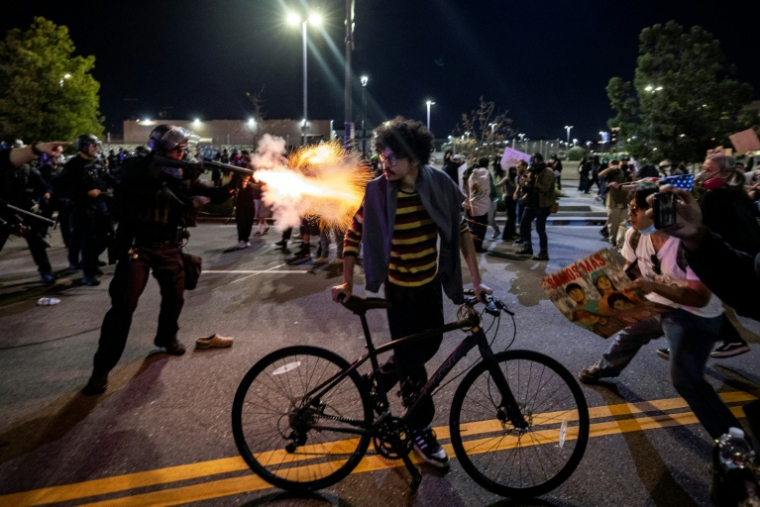 Un policier de Los Angeles tire avec une arme non létale, le 30 janvier 2026 dans la ville californienne durant une manifestation contre la police de l'immigration ( AFP / ETIENNE LAURENT )