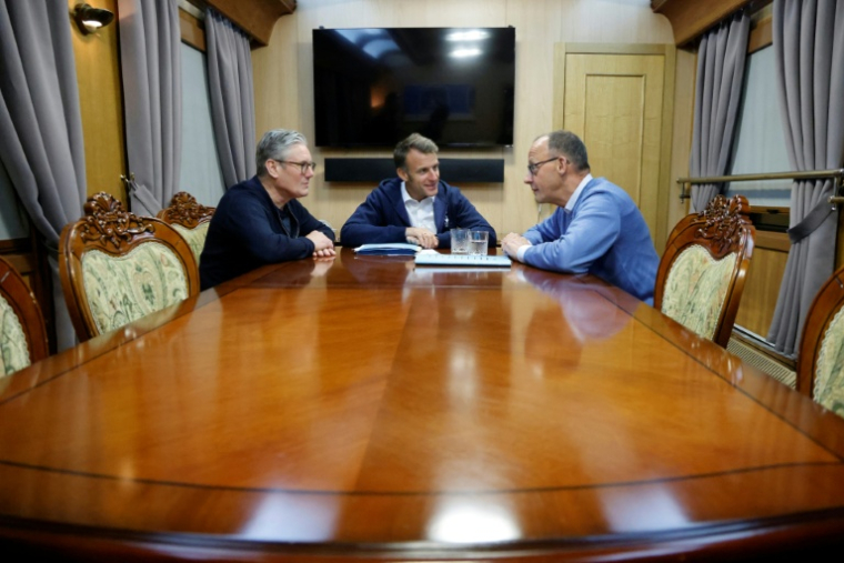 Emmanuel Macron entouré de Keir Starmer (gauche) et Friedrich Merz (droite) lors d'une réunion trilatérale à bord d'un train pour l'Ukraine, le 9 mai 2025 ( POOL / Ludovic MARIN )