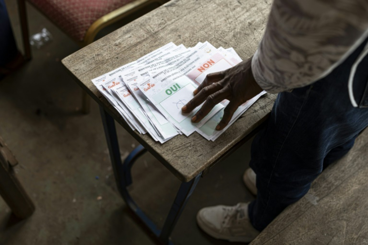 Un employé de la Direction générale des élections de Guinée (DGE) compte les bulletins de vote du bureau de vote de l'école primaire de Taouyah à Conakry le 21 septembre 2025, à l'issue du vote organisé par les militaires au pouvoir sur un projet de nouvelle Constitution ( AFP / PATRICK MEINHARDT )