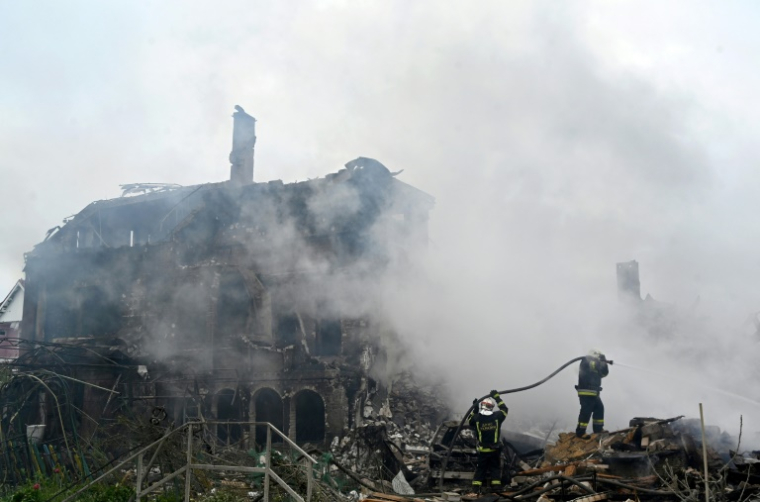 Des pompiers interviennent sur un incendie dans des maisons endommagées par une frappe russe dans la région de Kiev, le 25 mai 2025 en Ukraine ( AFP / Sergei SUPINSKY )