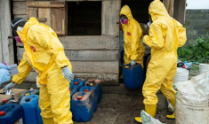 Des membres de l'Agence nationale nigériane de lutte contre les stupéfiants (NDLEA) transportent des fûts de produits chimiques lors d'une opération visant à démanteler un laboratoire clandestin de méthamphétamine abandonné à Iroto, dans l'Etat d'Ogun, le 29 juillet 2026 ( AFP / TOYIN ADEDOKUN )