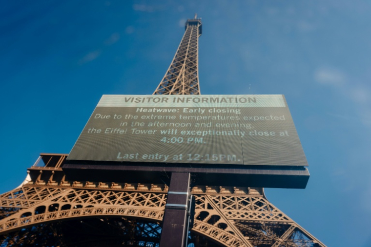 Un panneau d'affichage annonce la fermeture anticipée de la tour Eiffel en raison de la canicule, le 11 juillet 2026 à Paris  ( AFP / Dimitar DILKOFF )