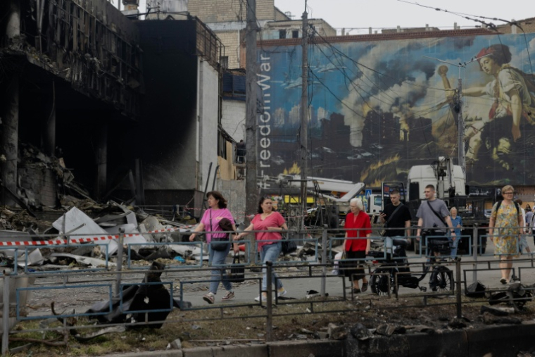 Des habitants passent devant un centre commercial endommagé à la suite des frappes russes à Kiev, le 25 mai 2026 ( AFP / Tetiana DZHAFAROVA )