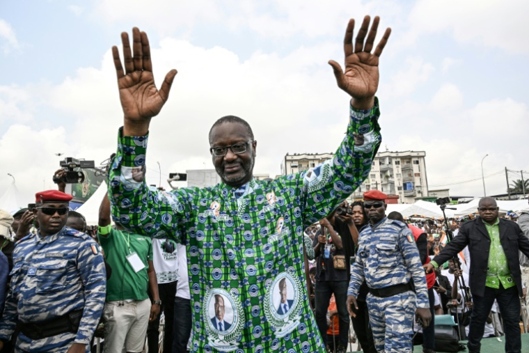 Tidjane Thiam (c), président du Parti démocratique de Côte d'Ivoire (PDCI), salue ses partisans à son arrivée pour un meeting de mobilisation pour l'élection présidentielle d'octobre 2025, à Yopougon, commune populaire d'Abidjan, le 15 février 2025 ( AFP / Sia KAMBOU )