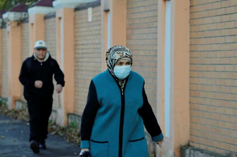 Une femme porte un masque de protection alors qu'elle passe près de l'institut de lutte contre la peste à Irkoutsk, le 7 octobre 2026 en Russie ( AFP / TATYANA MAKEYEVA )