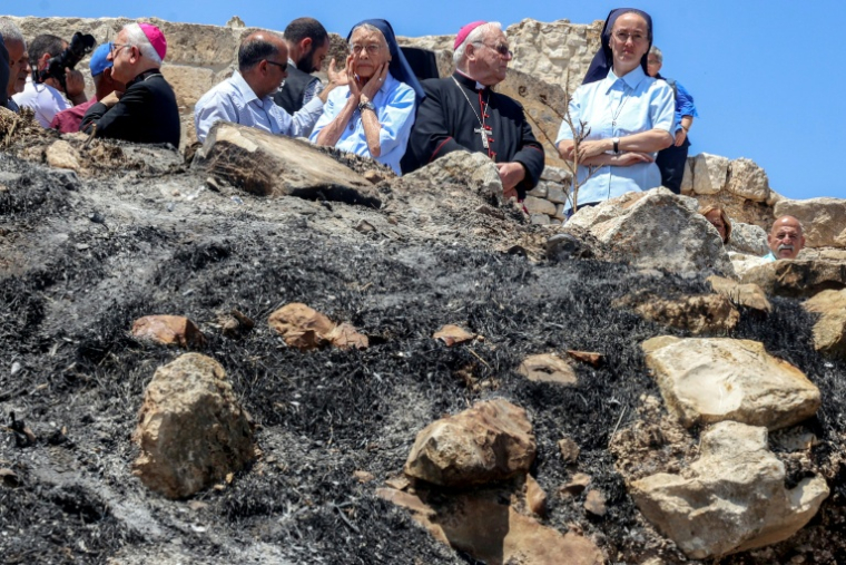 Des religieuses et des ecclésiastiques catholiques devant l'église Saint-Georges du Ve siècle dans le village chrétien palestinien de Taybeh, au nord-est de Ramallah en Cisjordanie occupée, le 14 juillet 2025 ( AFP / Zain JAAFAR )
