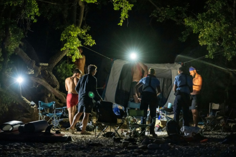 Des gendarmes contrôlent des touristes lors d'une opération de prévention contre les bivouacs illégaux susceptibles de provoquer un départ de feu, le 8 août 2026 autour du lac de Sainte-Croix, aux portes des Gorges du Verdon ( AFP / Miguel MEDINA )