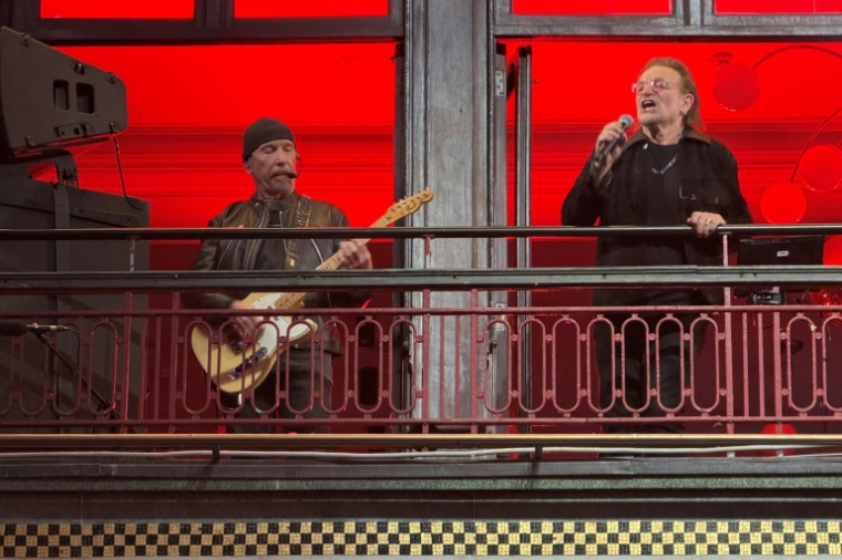 The Edge (G) et Bono (D) du groupe de rock irlandais U2 lors d'un concert surprise au balcon du Bewley's Oriental Cafe dans le centre de Dublin, le 25 septembre 2026 ( AFP / Peter MURPHY )