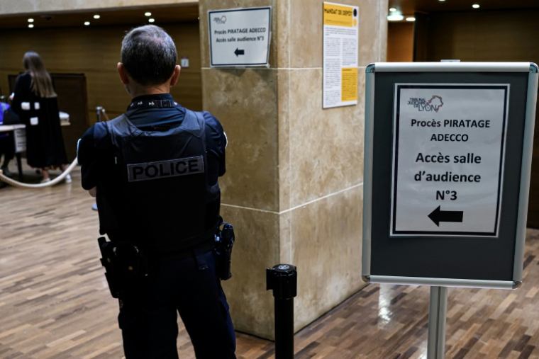 Un policier dans le hall du tribunal correctionnel de Lyon à l'ouverture du procès de piratage massif des donnée d'Adecco, le 16 juin 2025 ( AFP / JEAN-PHILIPPE KSIAZEK )