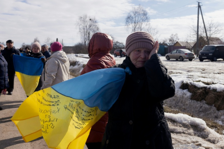 Une femme en larmes sur le bord de la route au  passage d'un convoi de soldats ukrainiens libérés par les Russes après un échange de prisonniers, le 6 mars 2026 dans un lieu non précisé dans le nord de l'Ukraine ( AFP / Tetiana DZHAFAROVA )