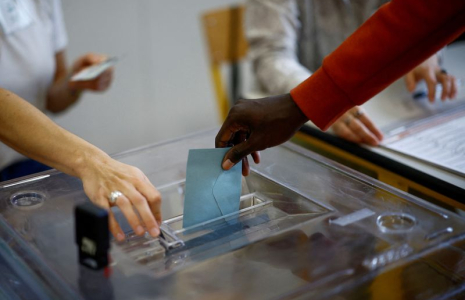 Une personne vote dans un bureau de vote à Paris au deuxième tour des élections législatives