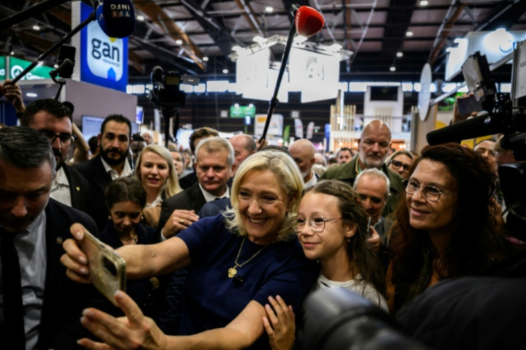 Marine Le Pen, candidate du RN à la présidentielle, fait un selfie avec des sympathisantes lors de sa visite au Sommet de l'élevage à Cournon-d'Auvergne, le 7 octobre 2026 dans le Puy-de-Dôme ( AFP / JEFF PACHOUD )