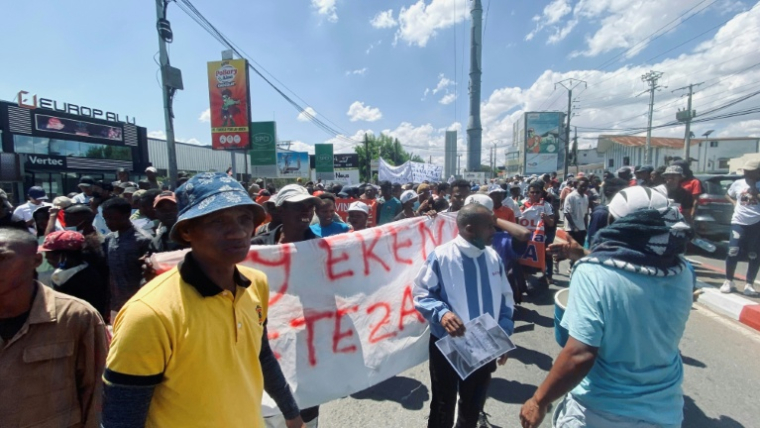 Des partisans tiennent une banderole lors d'une marche de soutien au président malgache Andry Rajoelina à Antananarivo, le 4 octobre 2025 à Magadascar ( AFP / RIJASOLO )
