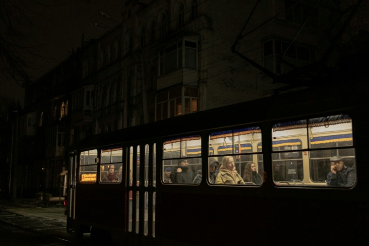 Un tramway circule dans une rue non éclairée à Kyiv, le 16 novembre 2025, pendant les heures de coupure de courant qui ont suivi des attaques de missiles et de drones russes contre les infrastructures énergétiques ukrainiennes ( AFP / Roman PILIPEY )