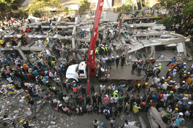Secouristes et bénévoles à l'oeuvre près d'un immeuble en ruines après un puissant séisme, à Cali en Colombie, le 11 août 2026  ( AFP / JOAQUIN SARMIENTO )