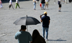 Des touristes visient Bruxelles à l'abri sous un parapluie pour se protéger du soleil lors d'une vague de chaleur le 27 mai 2026, en Belgique ( AFP / Nicolas TUCAT )