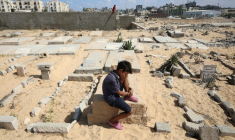 Un enfant assis sur une tombe d'un cimetière de Khan Younès le 25 septembre 2025 ( AFP / Omar AL-QATTAA )