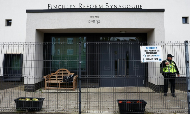 (PHOTO ARCHIVES) Un agent de sécurité devant la synagogue de Finchley, dans le quartier de North Finchley, dans le nord de Londres, le 15 avril 2026, après une attaque perpétrée contre le lieu de culte aux petites heures du matin ( AFP / Toby Shepheard )