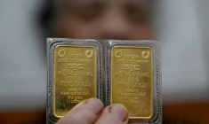 Une femme présentant deux taëls d'or (75g) à Hanoï, au Vietnam, le 27 janvier 2026 ( AFP / Nhac NGUYEN )