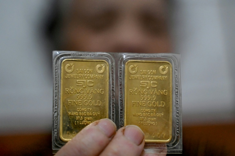 Une femme présentant deux taëls d'or (75g) à Hanoï, au Vietnam, le 27 janvier 2026 ( AFP / Nhac NGUYEN )