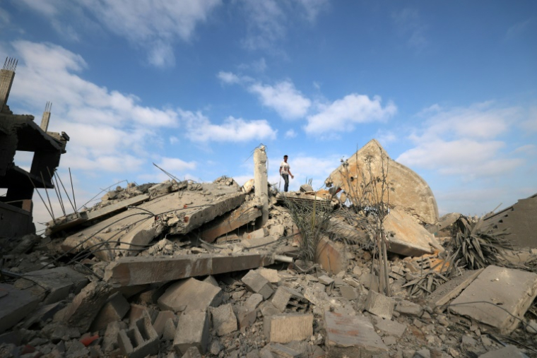 Un Palestinien au sommet des décombres d'un bâtiment touché par une frappe israélienne dans le camp de réfugiés de Bureij, dans le centre de la bande de Gaza, le 10 juillet 2025 ( AFP / Eyad BABA )