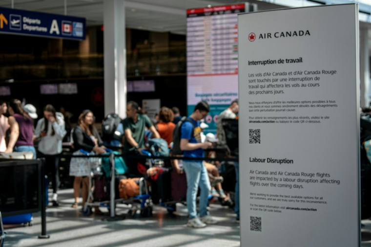 Des passagers en attente à l'aéroport de Montréal (Canada) le 16 août 2025 à la suite d'un mouvement de grève des hôtesses et stewards d'Air Canada ( AFP / ANDREJ IVANOV )